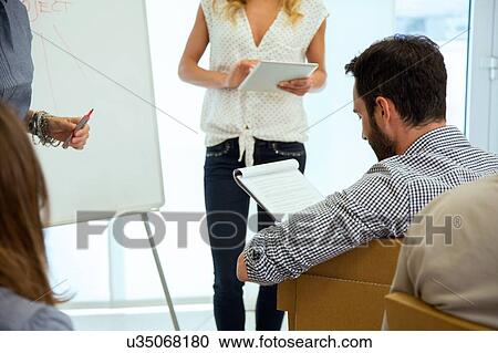 Stock Image - Business team at presentation in office. Fotosearch