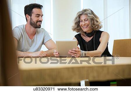 Businesswoman and male designer meeting in office View Large Photo Image Stock Image - Businesswoman and male designer meeting in office. Fotosearch