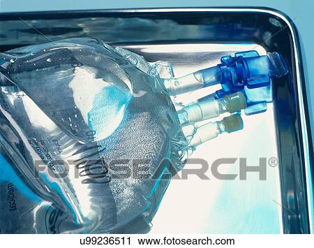 Stock Image - Close up of sealed intravenous drip bag on a surgical tray. Fotosearch