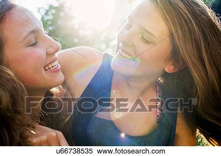 Close up of two teenage girls in sunlit park View Large Photo Image Stock Photography - Close up of two teenage girls in sunlit park. Fotosearch
