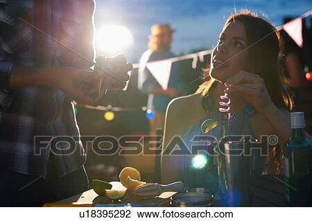 Stock Image - Couple at early evening party. Fotosearch
