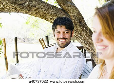Stock Image - Couple at safari lodge, Kafue National Park, Zambia. Fotosearch