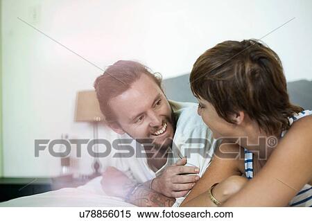 Stock Photography - Couple chatting in bed. Fotosearch