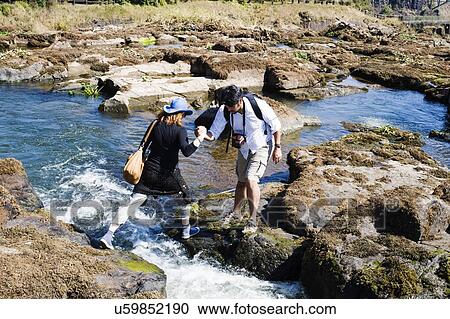 Couple crossing river, near Victoria Falls, Zambia View Large Photo Image Stock Image - Couple crossing river, near Victoria Falls, Zambia. Fotosearch
