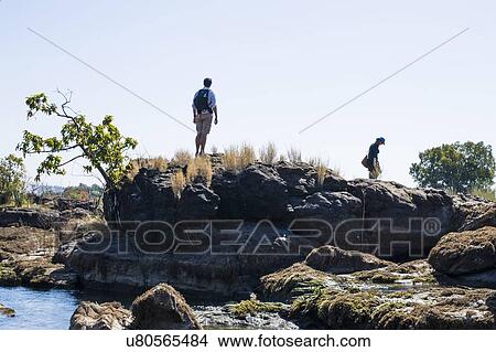 Couple exploring on rocks, near Victoria Falls, Zambia View Large Photo Image Picture - Couple exploring on rocks, near Victoria Falls, Zambia. Fotosearch