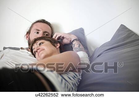 Stock Image - Couple in loving embrace in bed. Fotosearch