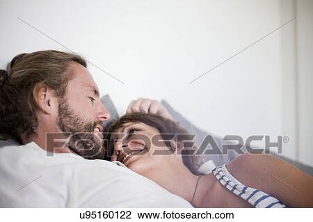 Stock Image - Couple in loving embrace in bed. Fotosearch