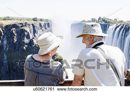 Couple looking out to Victoria Falls, Zambia View Large Photo Image Stock Image - Couple looking out to Victoria Falls, Zambia. Fotosearch