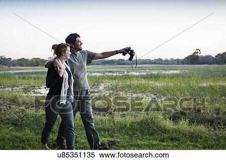 Stock Photography - Couple on safari exploring landscape, Kafue National Park, Zambia. Fotosearch