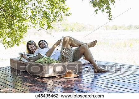 Couple reclining on seats at safari lodge, Kafue National Park, Zambia View Large Photo Image Stock Image - Couple reclining on seats at safari lodge, Kafue National Park, Zambia. Fotosearch