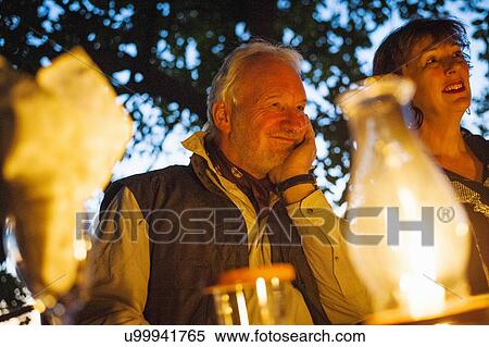 Stock Photography - Couple relaxing at dinner table at safari lodge, Kafue National Park, Zambia. Fotosearch
