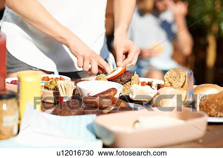 Cropped shot of male hands preparing burger at rooftop party View Large Photo Image Stock Image - Cropped shot of male hands preparing burger at rooftop party. Fotosearch