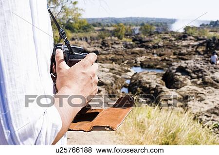 Cropped shot of man using camera near Victoria Falls, Zambia View Large Photo Image Stock Photo - Cropped shot of man using camera near Victoria Falls, Zambia. Fotosearch