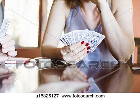 Stock Photo - Cropped shot of young woman playing cards. Fotosearch