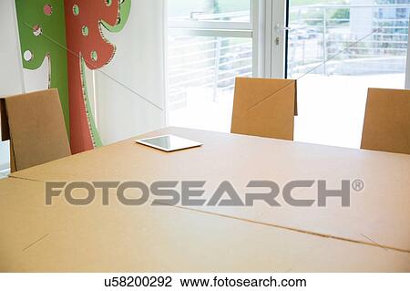 Stock Image - Digital tablet on empty boardroom table. Fotosearch