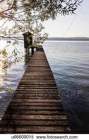 Stock Photography - Diminishing perspective of boathouse and pier at lake, Schondorf, Ammersee, Bavaria, Germany. Fotosearch