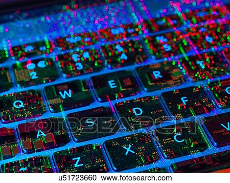 Stock Image - Double exposure of the inside and out of a laptop computer showing the electronic components under the keyboard. Fotosearch