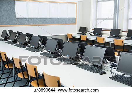 Picture - Empty classroom with rows of personal computers on desk. Fotosearch