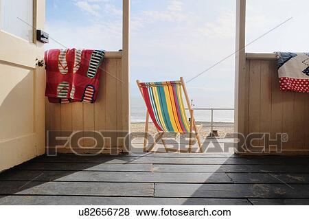 Stock Photo - Empty deckchair outside beach hut, rear view. Fotosearch