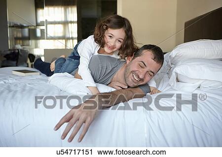 Father and daughter playing on bed View Large Photo Image Stock Image - Father and daughter playing on bed. Fotosearch