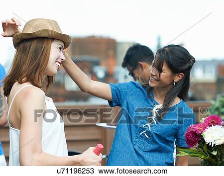 Female friends chatting at rooftop party View Large Photo Image Stock Image - Female friends chatting at rooftop party. Fotosearch