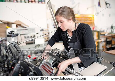 Female letterpress printer preparing print machine in workshop View Large Photo Image Picture - Female letterpress printer preparing print machine in workshop. Fotosearch