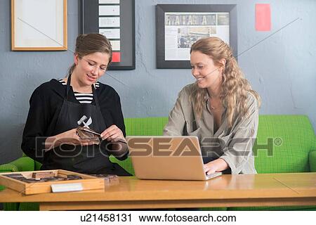 Stock Image - Female printer and designer working with laptop in workshop office. Fotosearch