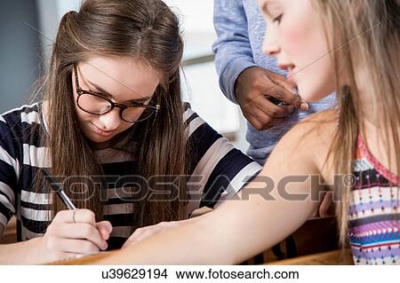 Female student looking friend's work View Large Photo Image Picture - Female student looking friend's work. Fotosearch