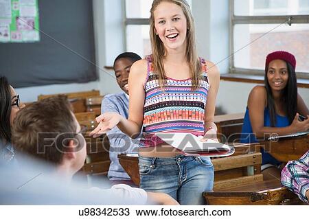Stock Image - Female student making presentation to class. Fotosearch