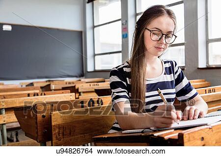 Female student working in empty classroom View Large Photo Image Picture - Female student working in empty classroom. Fotosearch