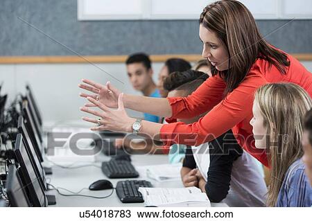 Female teacher explaining to high school students in class View Large Photo Image Stock Image - Female teacher explaining to high school students in class. Fotosearch