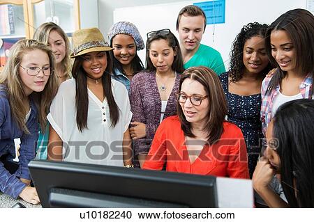 Female teacher showing computer to high school students View Large Photo Image Stock Image - Female teacher showing computer to high school students. Fotosearch