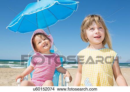 Female toddler and sister looking up from beach View Large Photo Image Picture - Female toddler and sister looking up from beach. Fotosearch