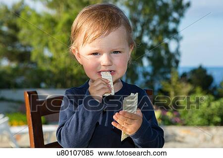 Female toddler eating crisp bread on patio View Large Photo Image Stock Photography - Female toddler eating crisp bread on patio. Fotosearch