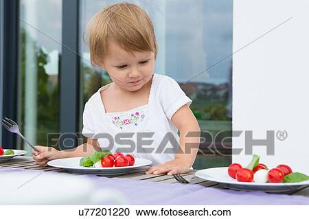 Female toddler looking at lunch plates on patio View Large Photo Image Stock Image - Female toddler looking at lunch plates on patio. Fotosearch