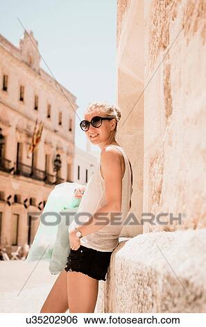 female tourist leaning against wall in Ciutadella, Menorca, Spain View Large Photo Image Stock Photograph - female tourist leaning against wall in Ciutadella, Menorca, Spain. Fotosearch