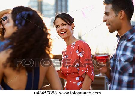 Stock Image - Friends at early evening party. Fotosearch