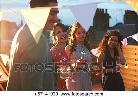 Stock Image - Friends at early evening party. Fotosearch