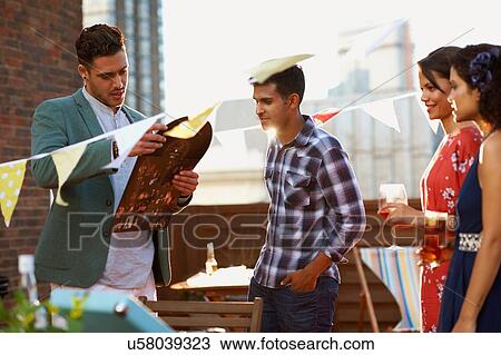 Stock Image - Friends at early evening party. Fotosearch