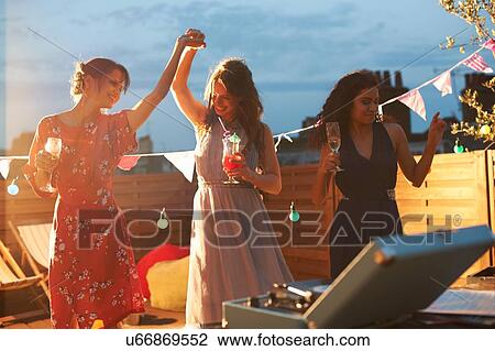 Friends dancing at early evening party View Large Photo Image Stock Image - Friends dancing at early evening party. Fotosearch