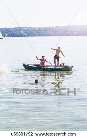 Friends jumping off boat and swimming in lake, Schondorf, Ammersee, Bavaria, Germany View Large Photo Image Stock Image - Friends jumping off boat and swimming in lake, Schondorf, Ammersee, Bavaria, Germany. Fotosearch