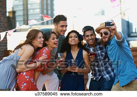 Friends taking selfie at early evening party View Large Photo Image Stock Photography - Friends taking selfie at early evening party. Fotosearch