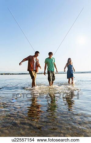 Front view of friends in a row walking ankle deep in water, Schondorf, Ammersee, Bavaria, Germany View Large Photo Image Picture - Front view of friends in a row walking ankle deep in water, Schondorf, Ammersee, Bavaria, Germany. Fotosearch