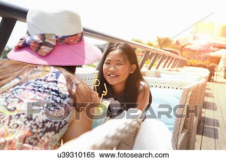 Stock Photography - Girl and mother at beach cafe, Zhuhai, Guangdong, China. Fotosearch