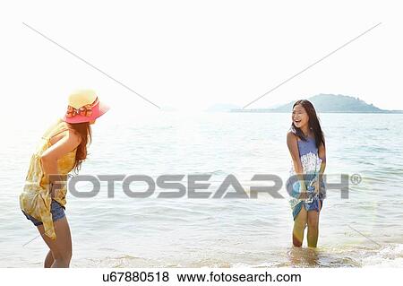 Stock Photo - Girl and mother paddling in sea, Zhuhai, Guangdong, China. Fotosearch