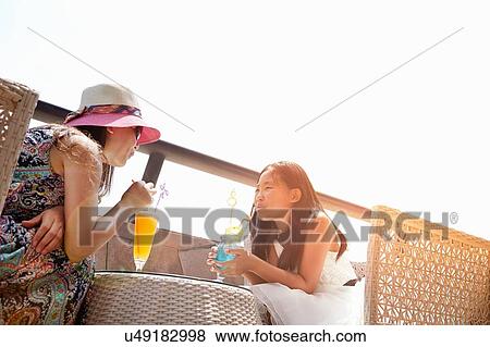 Girl and mother with soft drinks at beach cafe, Zhuhai, Guangdong, China View Large Photo Image Stock Photo - Girl and mother with soft drinks at beach cafe, Zhuhai, Guangdong, China. Fotosearch