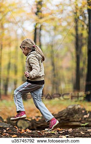 Girl jumping over tree trunk in autumn forest View Large Photo Image Stock Image - Girl jumping over tree trunk in autumn forest. Fotosearch