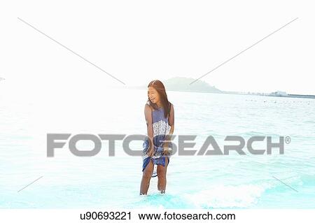 Stock Image - Girl paddling in sea, Zhuhai, Guangdong, China. Fotosearch