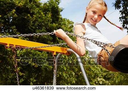 Girl with pigtails on swing looking at camera smiling View Large Photo Image Stock Photo - Girl with pigtails on swing looking at camera smiling. Fotosearch