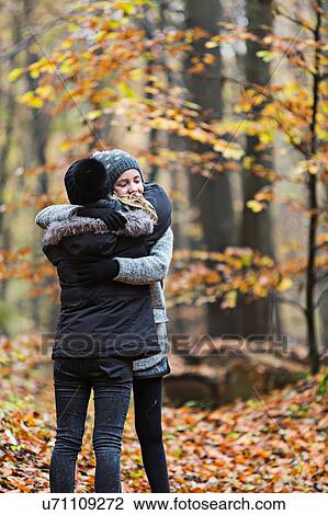 Girls hugging in autumn forest View Large Photo Image Stock Image - Girls hugging in autumn forest. Fotosearch